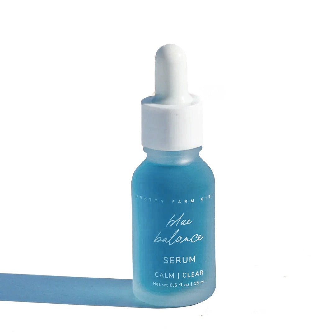 Blue face serum bottle with white dropper cap and blue liquid