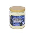 Scented candle in clear glass jar with gold lid, blue label reading smoke odor exterminator