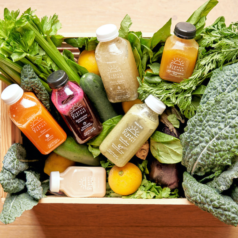 Organic botanical beverage variety bottles with fresh greens on a tray