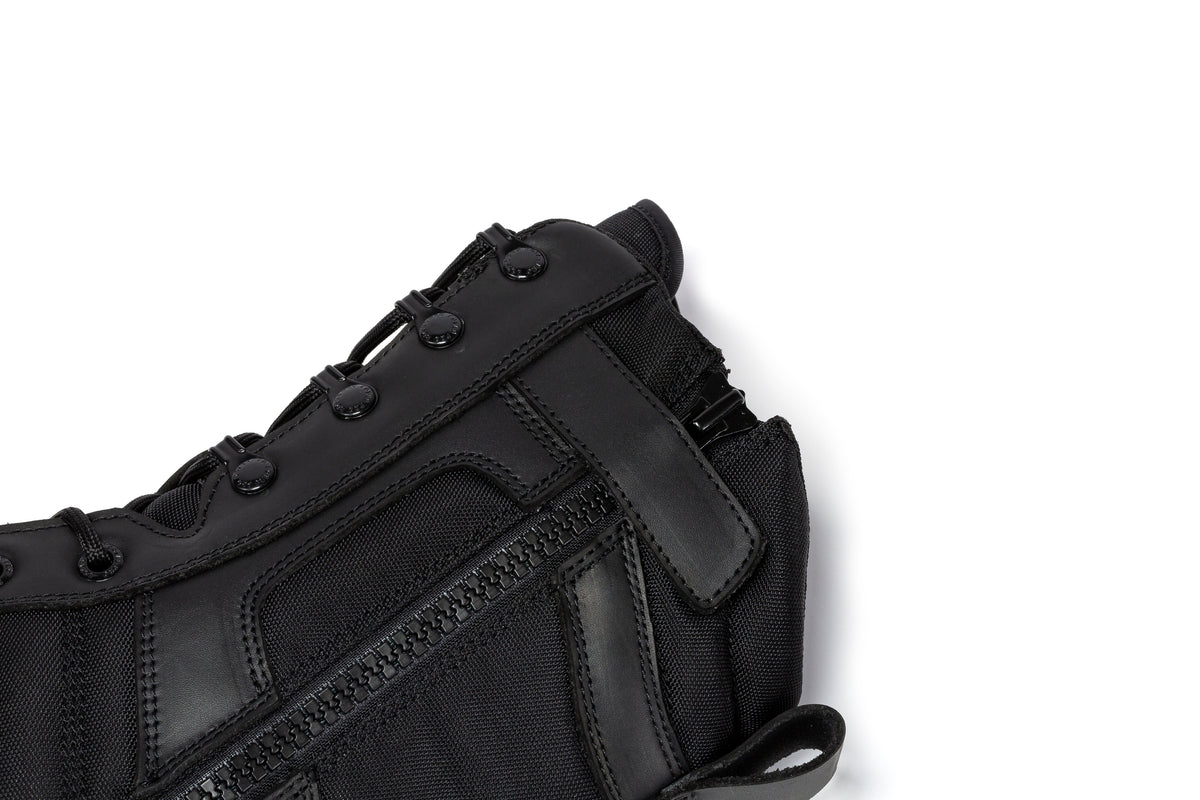 Men's black tactical boot upper close-up with lace loops and reinforced side stitching
