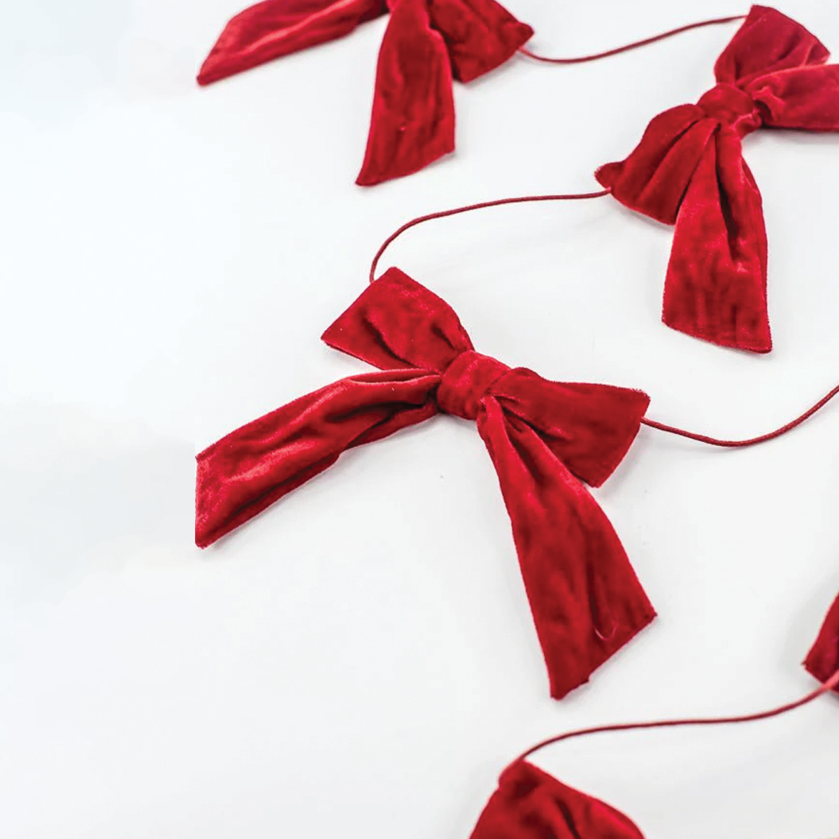 Red velvet bow garland section with several bow knots and ribbon tails
