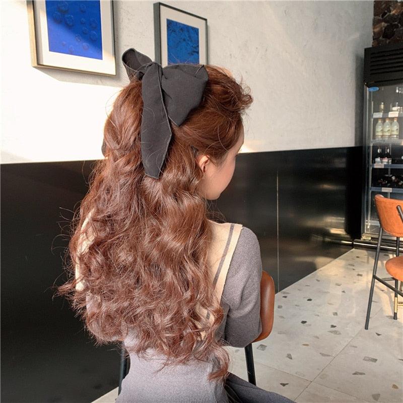 Dark gray satin bow hair scrunchie on long brown hair