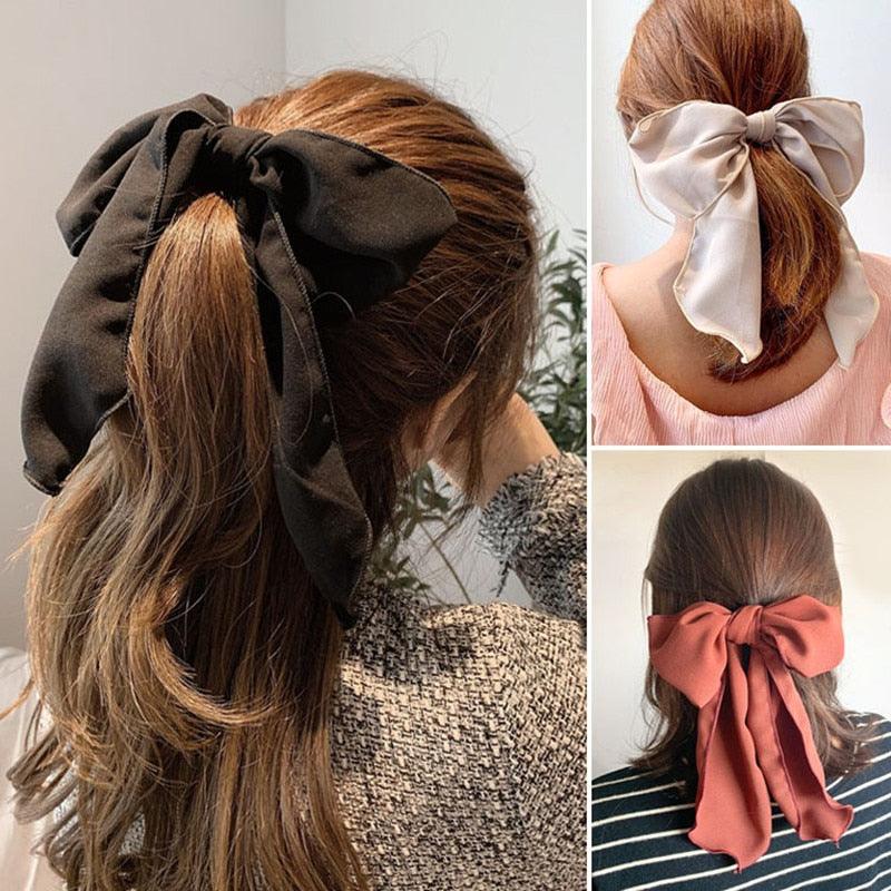 Black bowknot hair scrunchie with long fabric tails on a ponytail