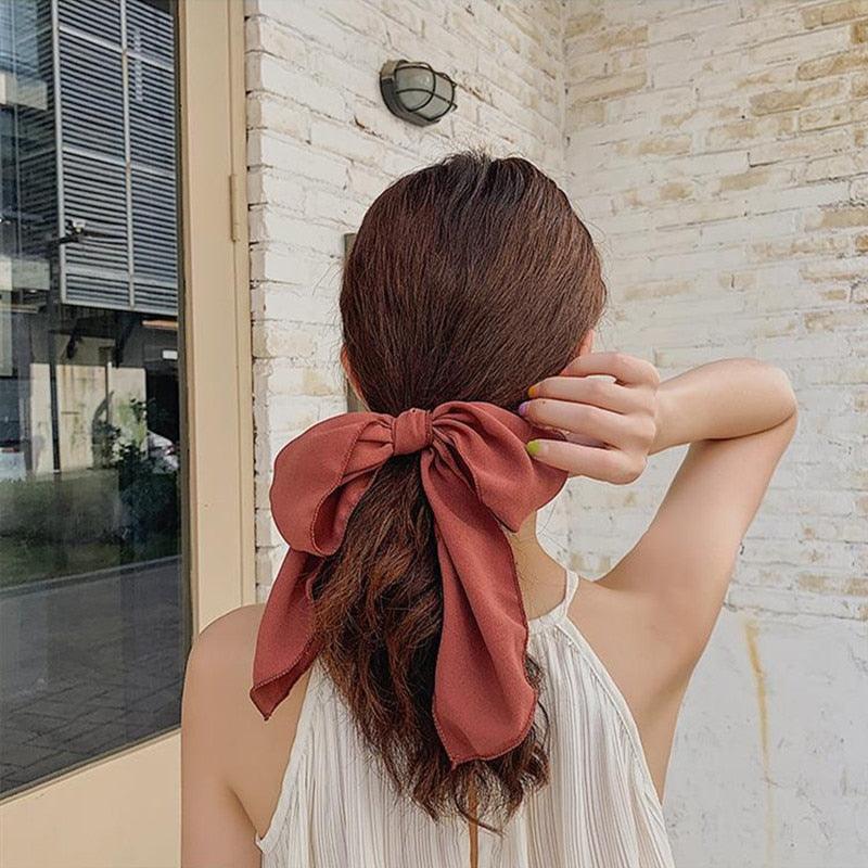 Burgundy bowknot hair scrunchie with large bow and flowing ribbon ends.