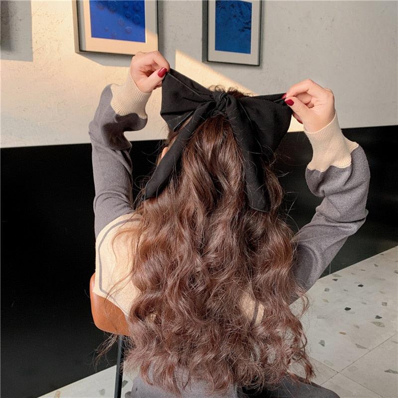 Black bowknot hair scrunchie with big bow and long ribbon streamers.