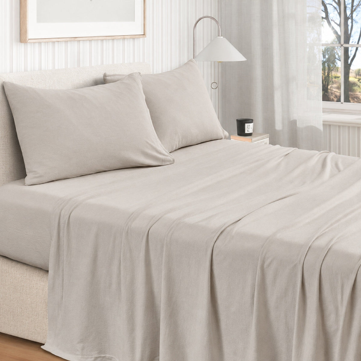 Jersey knit sheet set on bed with two pillows, light grey