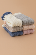Fluffy slipper socks set folded in blue, gray, and cream tones