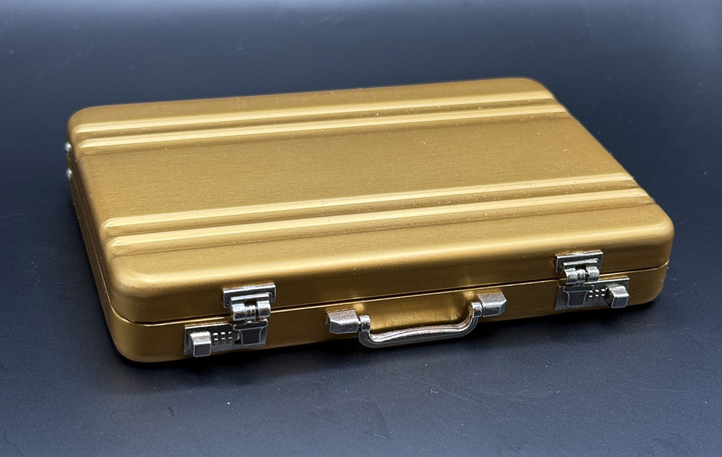 Gold mini briefcase with chrome latches and handle, front view.