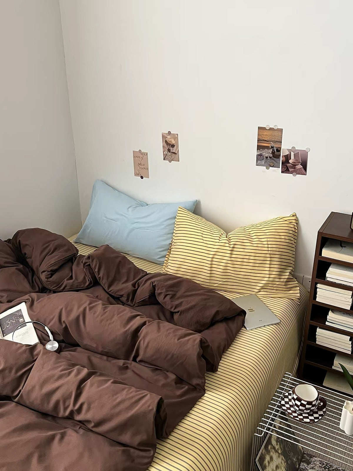 Dark brown bedding set featuring quilted comforter and striped pillow shams on bed