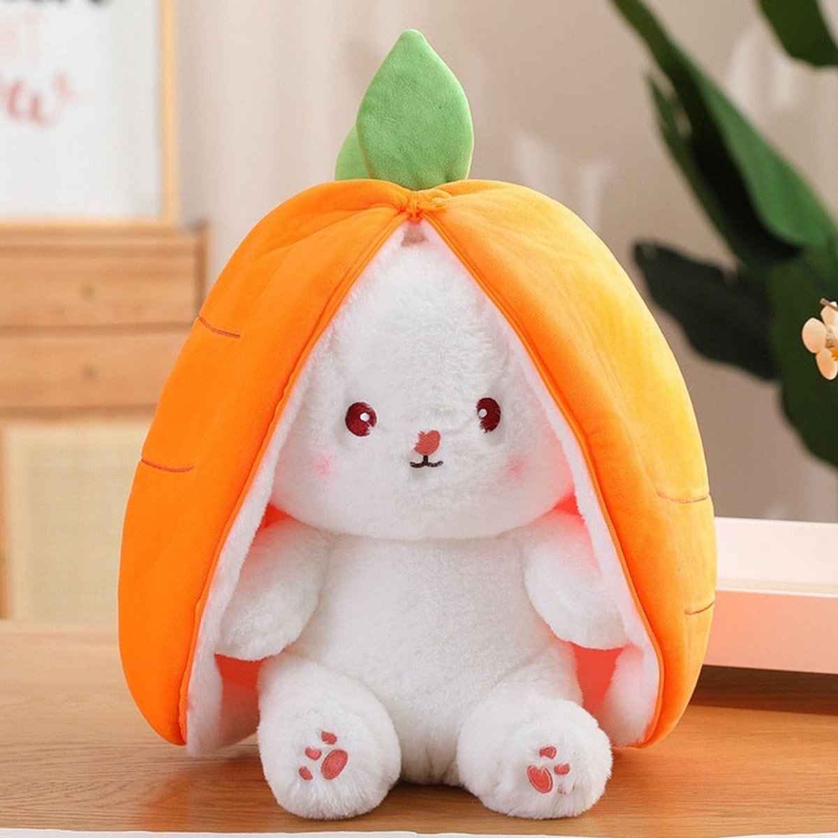 Reversible plush bunny toy in orange pod with green leaf, white bunny inside with red paws