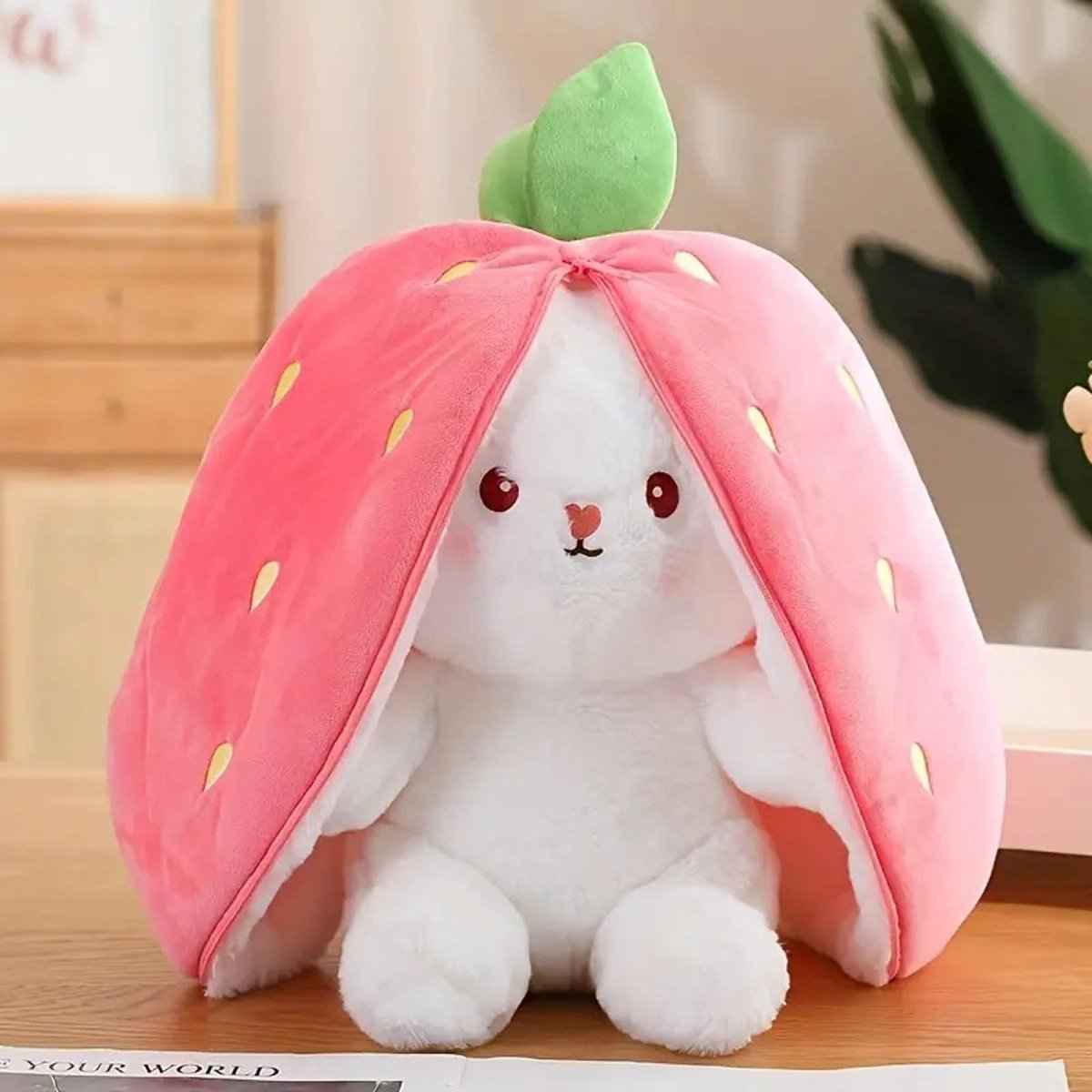 Reversible bunny plush toy with pink strawberry hood and green leaf top