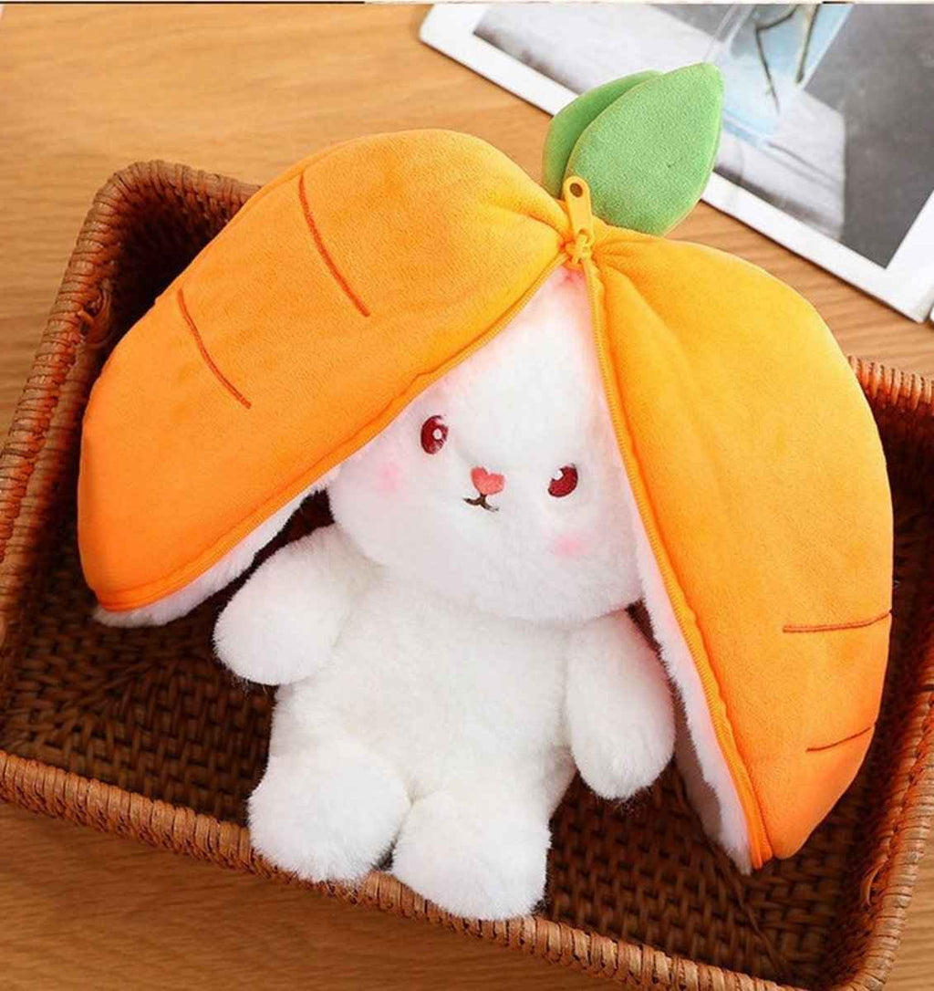 Reversible carrot bunny plush with orange hood and green leaf on a woven basket