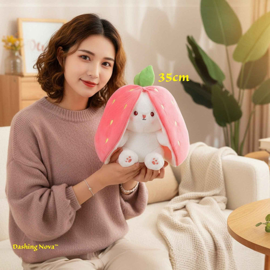Reversible pink bunny plush with white face, embroidered nose, and green leaf top