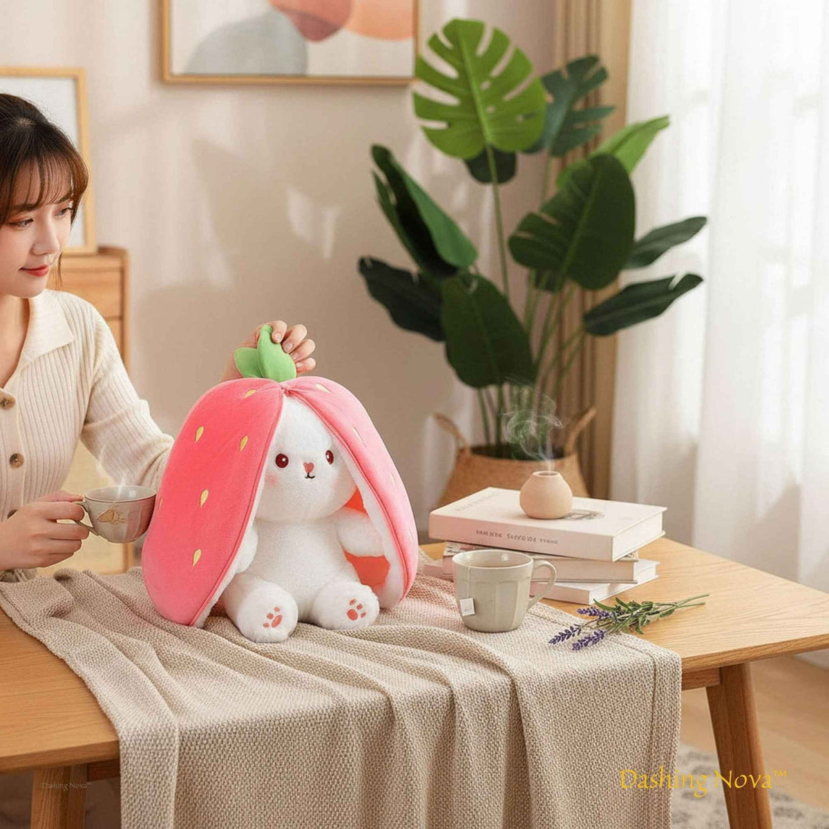 Pink bunny plush toy with strawberry-style ears and white embroidered face