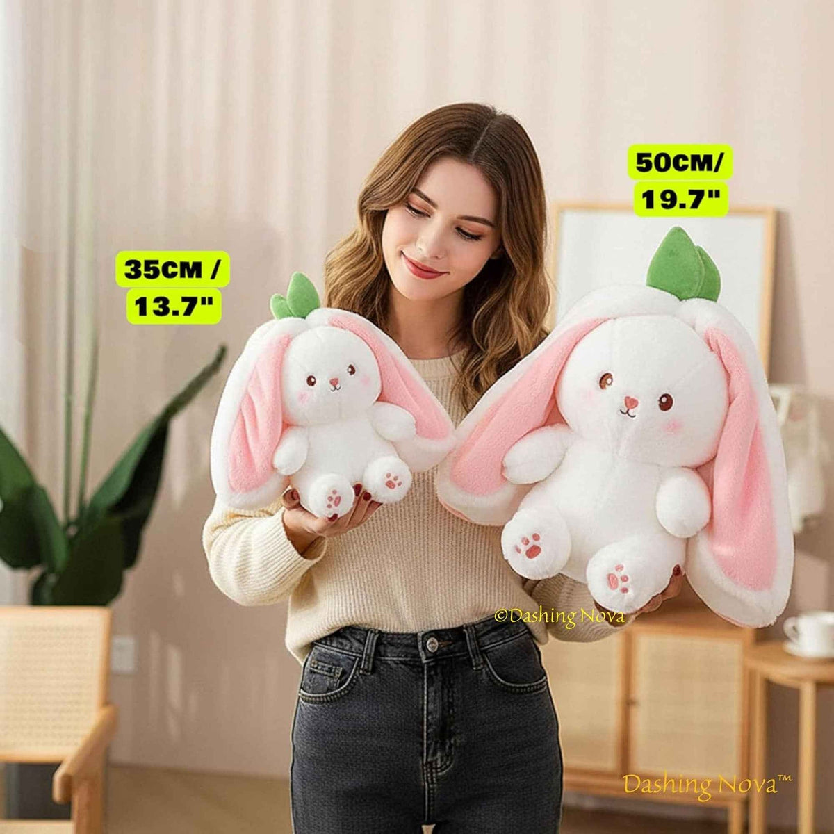 Pink bunny plush toy with long strawberry-style ears, held in arms