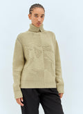 Women’s cream cashmere sweater with high turtleneck and tonal jacquard emblem