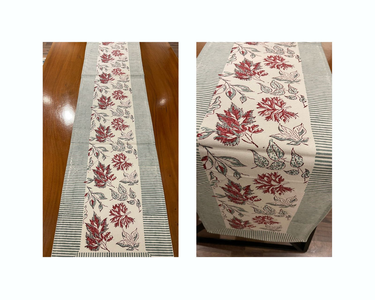 Table runner shown folded and laid out, featuring red leaf print and slate-blue stripes