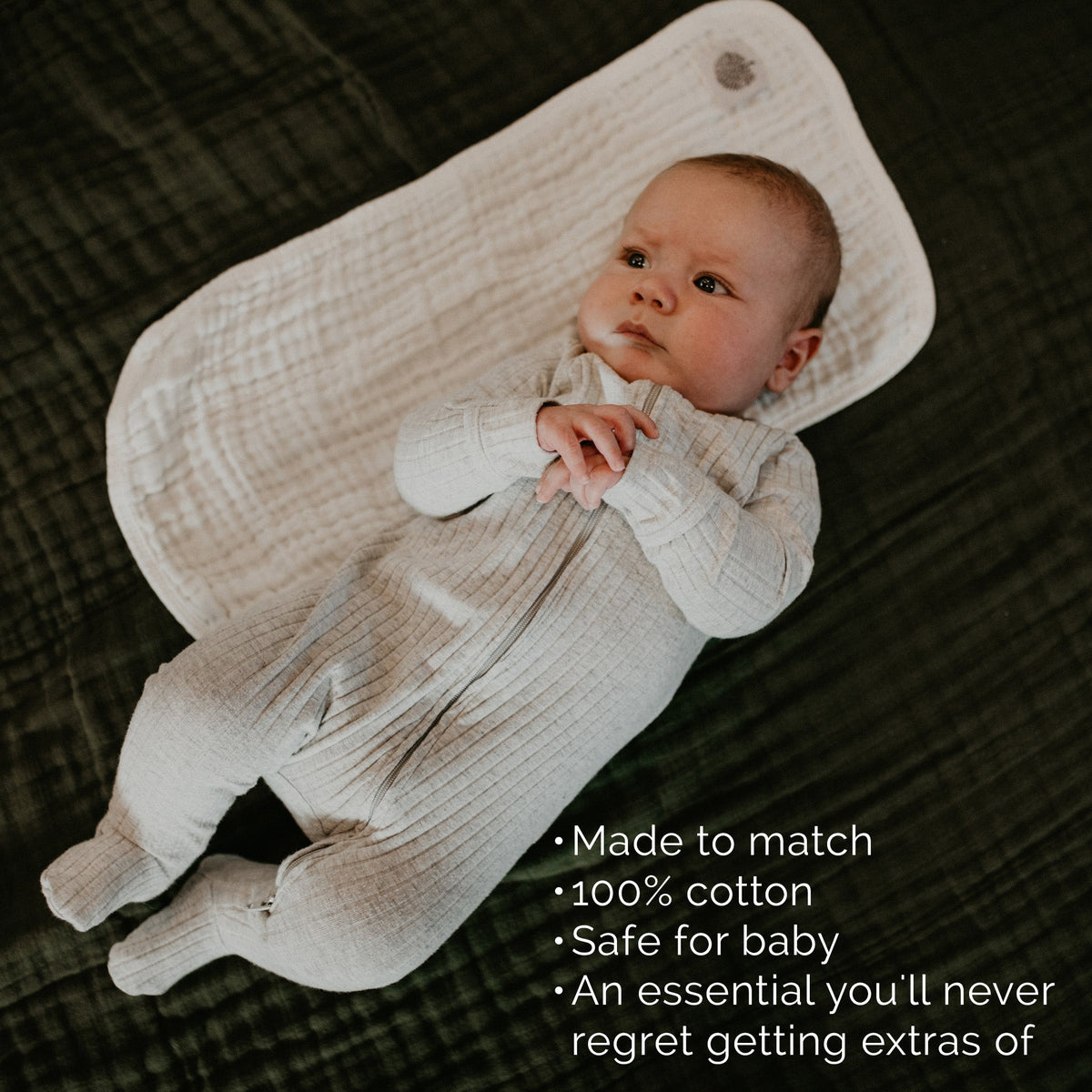 White muslin burp cloth draped over baby in textured fabric, rounded folded corners