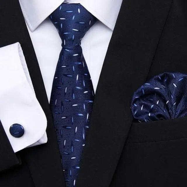 Deep blue geometric silk tie and matching pocket square with black jacket and shirt cufflinks