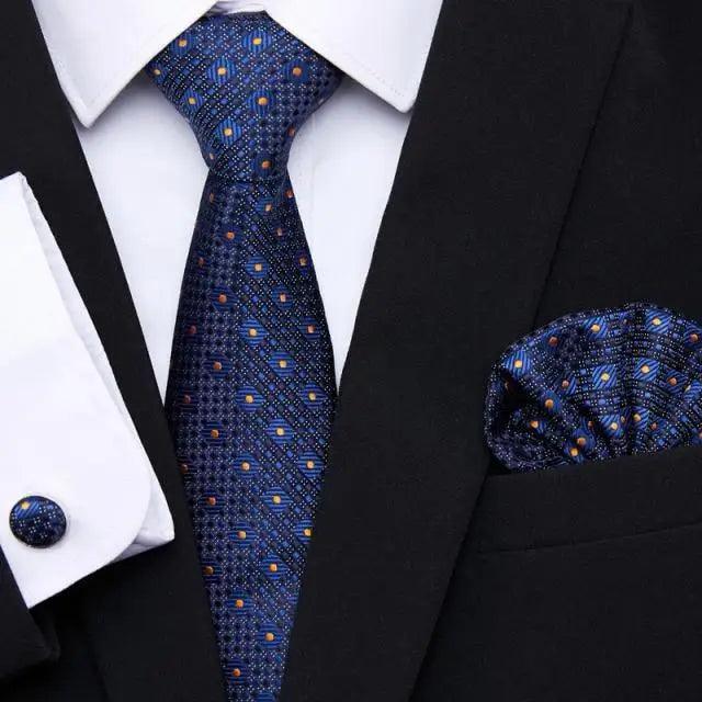Blue geometric silk tie and matching pocket square with black jacket and shirt cufflinks