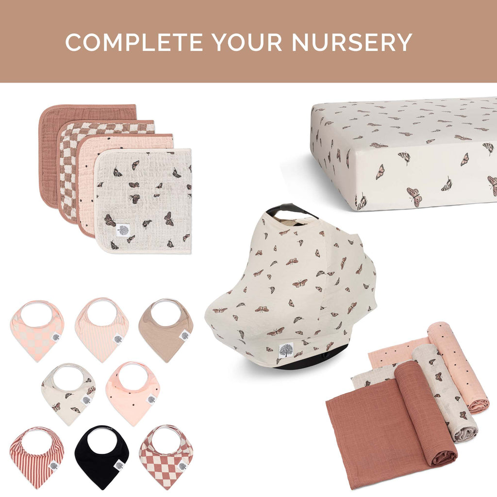Crib sheet in light cream with small butterfly-like print, folded and draped