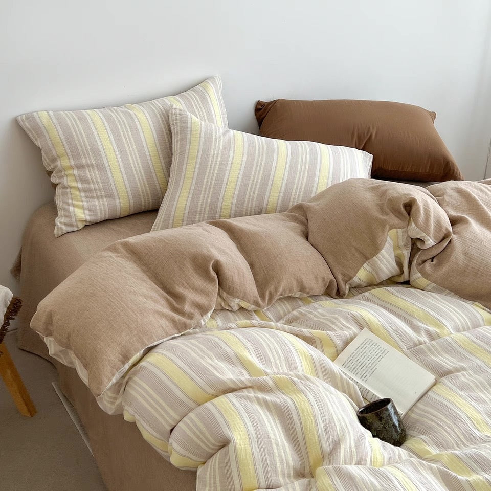 Butter yellow striped duvet cover set with matching pillowcases and button-tie accents.