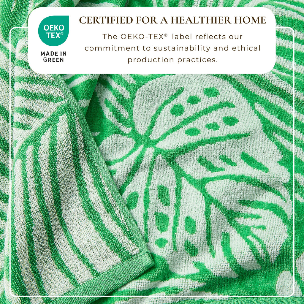 Green cotton velour towel close-up with white leaf-and-stem pattern