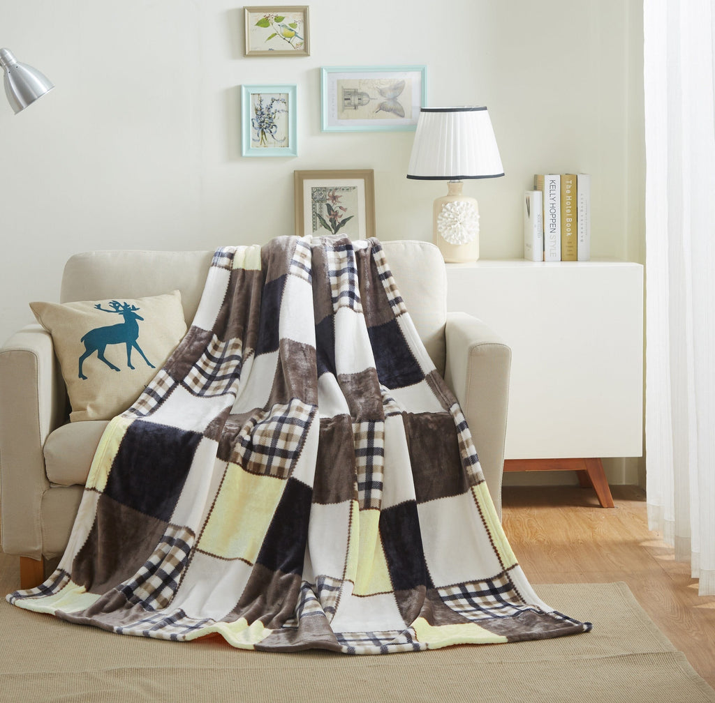 Patchwork plaid throw blanket on living room couch in brown, cream, and navy