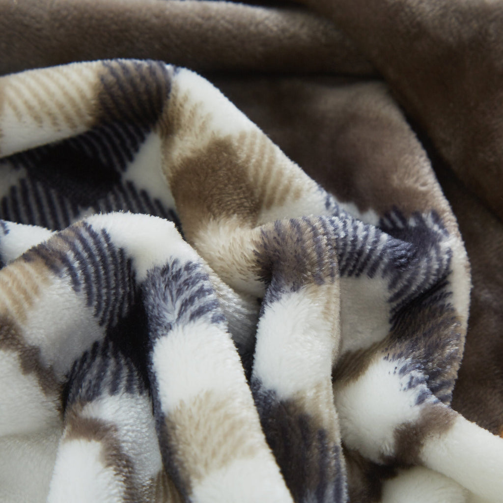 Close-up of soft plaid throw blanket with brown, cream, and navy sections