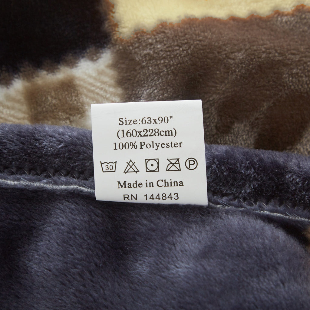 Close-up of plaid throw blanket fabric with sewn care label tag