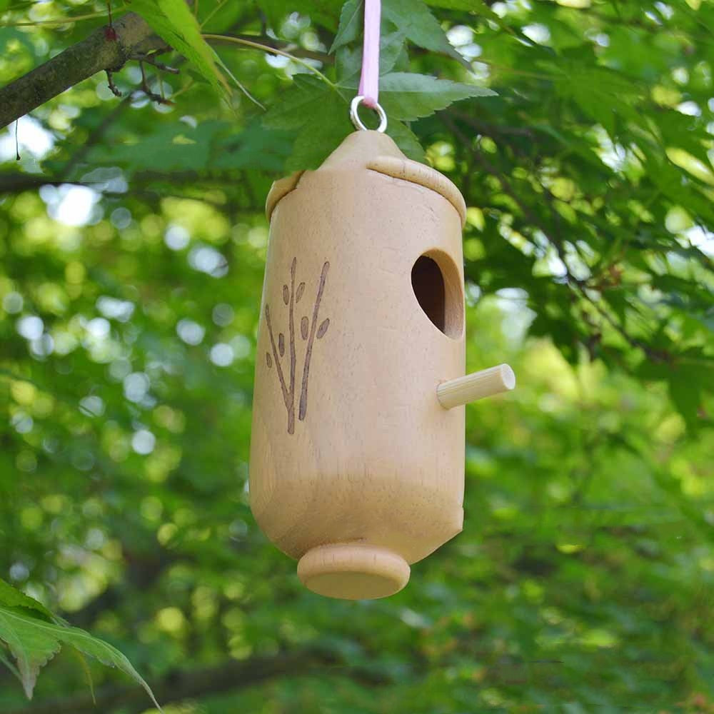 Hanging wooden birdhouse craft with side perch and round entry hole, leaf pattern detail.