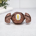 Patchouli bath bomb, dark brown round with crinkled wrap and center label