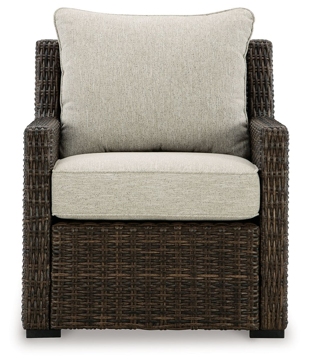 Brown woven lounge chair with beige seat and tall back cushion