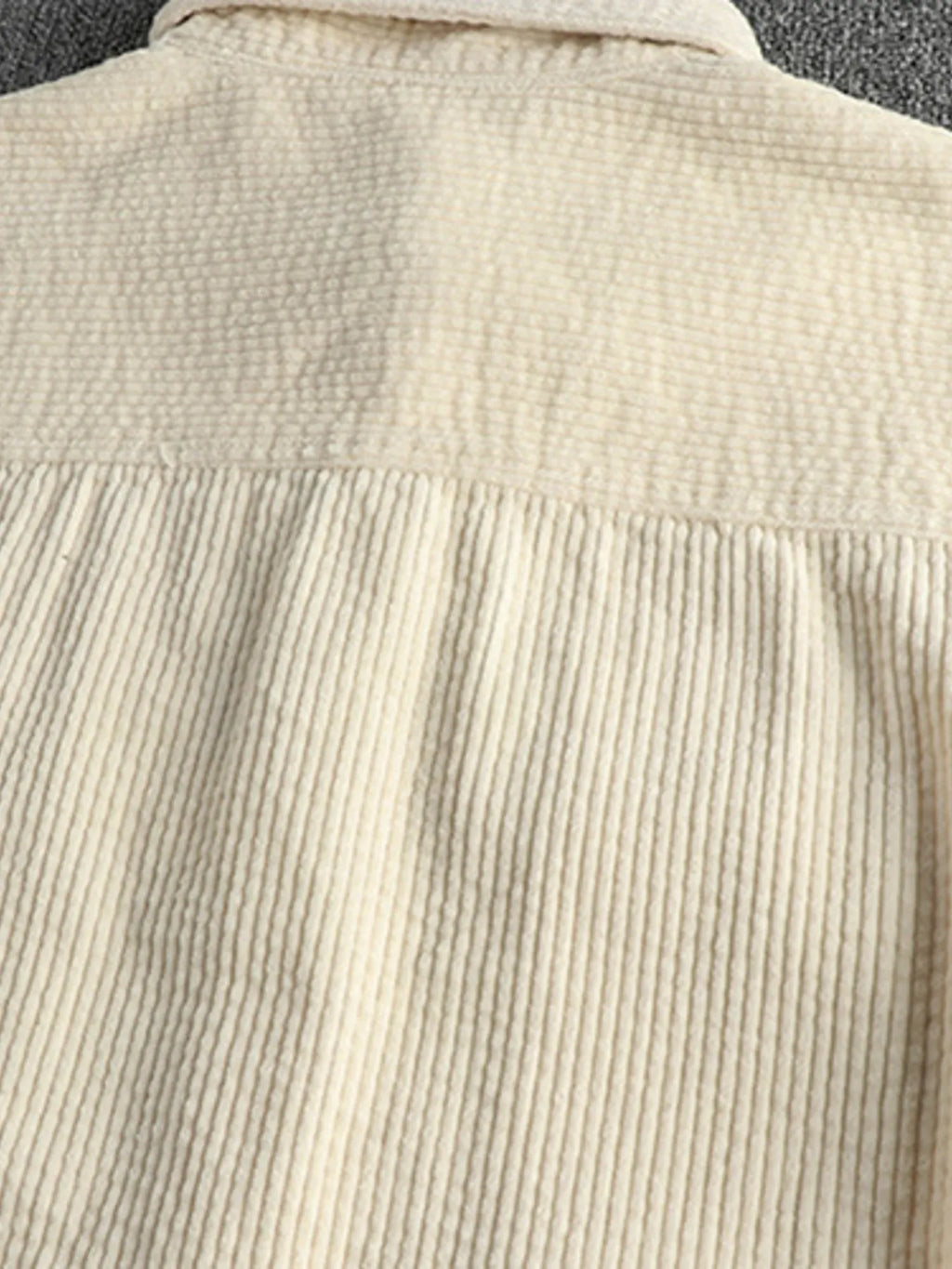 Close-up of light beige corduroy shirt back with yoke and vertical ribbed texture