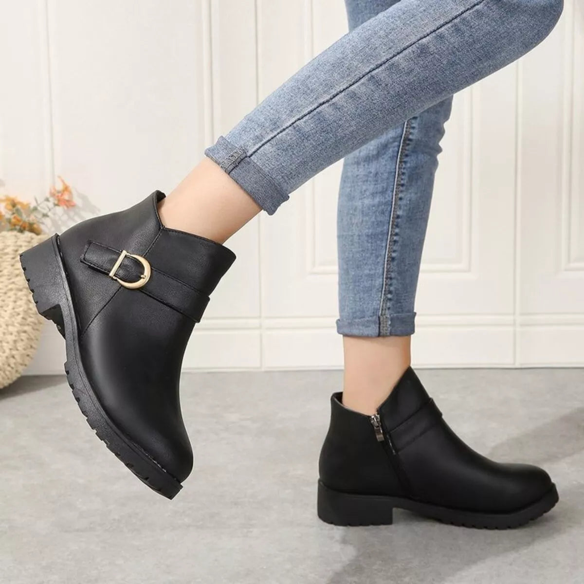Black ankle boots with gold buckle at instep and side zipper, chunky tread sole