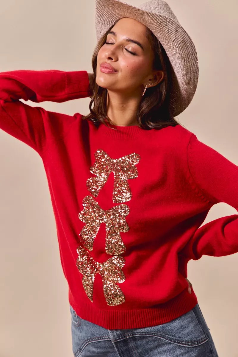 Red knit sweater with gold sequin bow ribbon embellishment on the front