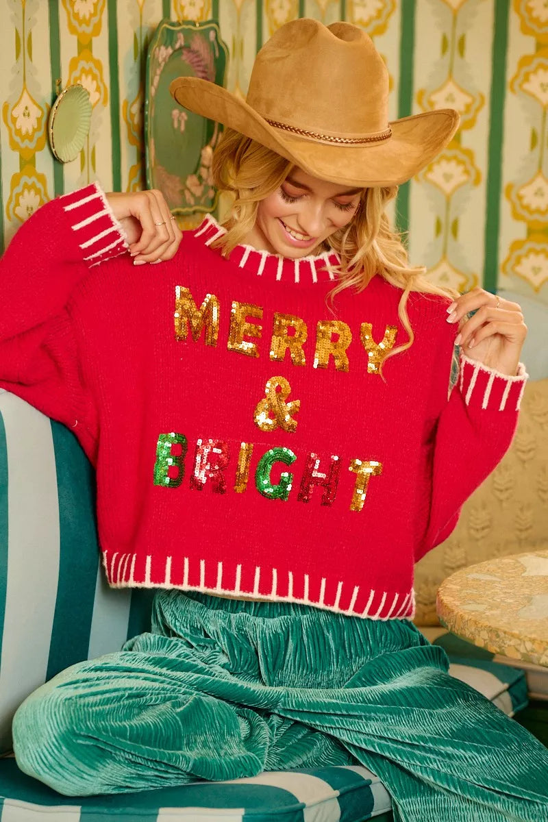 Red sequin Christmas sweater with “MERRY & BRIGHT” text and white fringe hem/cuffs
