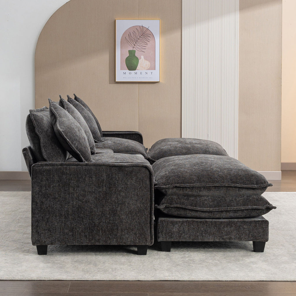 Dark gray sectional sofa with two large ottomans and square throw pillows