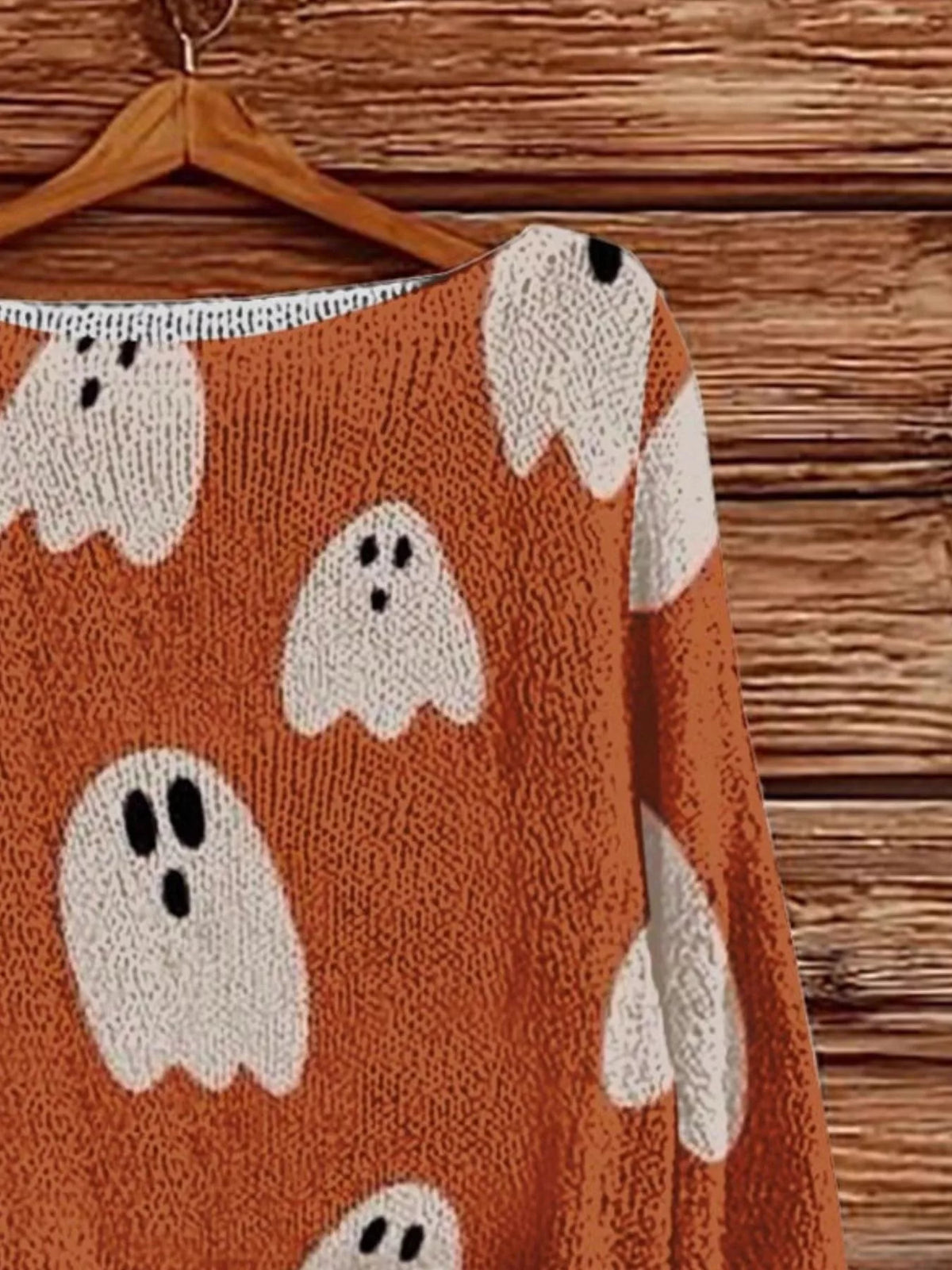 Orange Halloween boat-neck sweater close-up with white ghost graphic prints