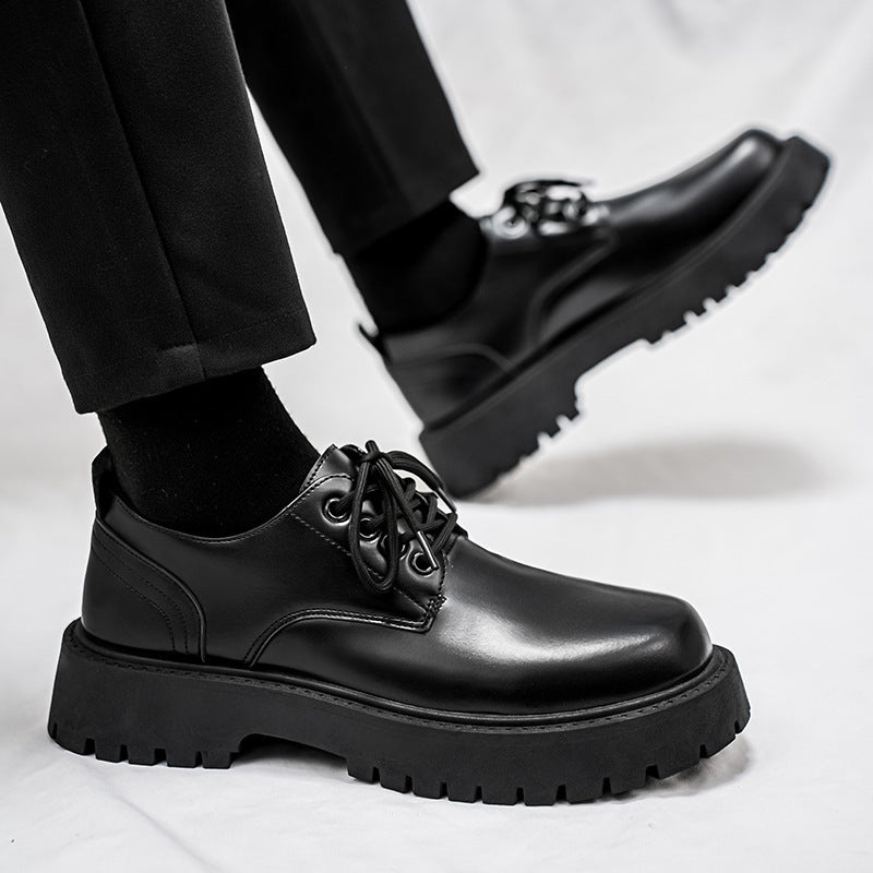 Black derby dress shoe close-up with lace eyelets and rugged platform sole.