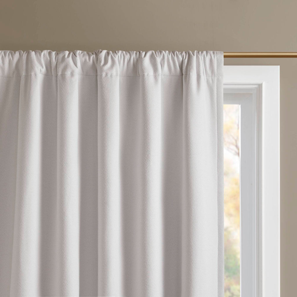 White blackout curtain panel with gathered top and rod pocket construction
