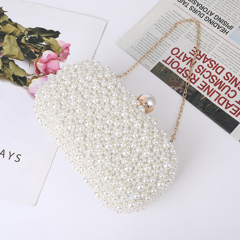 White pearl beaded clutch with round metal top clasp, angled top view