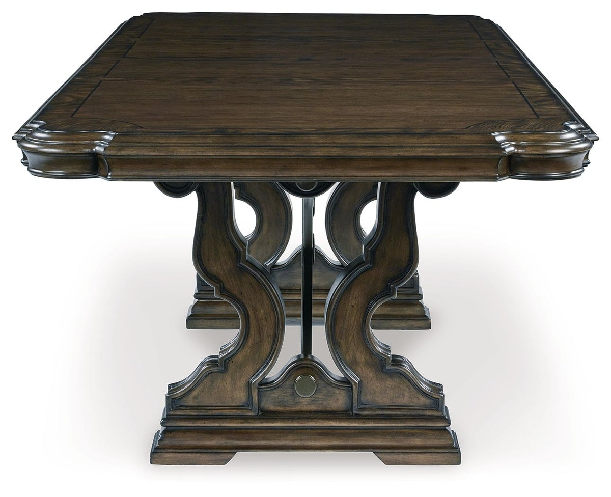 Dark brown dining extension table with slatted top edges and ornate central pedestal