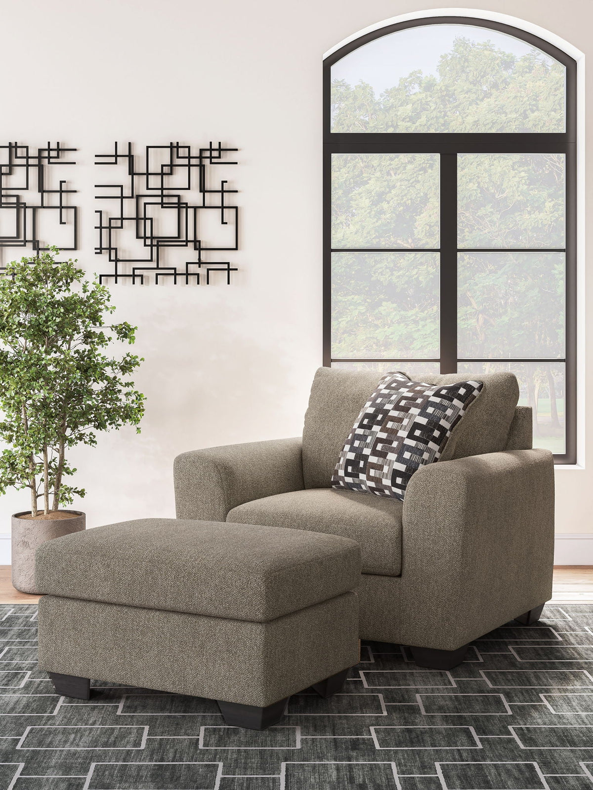 Beige fabric chair and ottoman with black-and-white geometric throw pillows