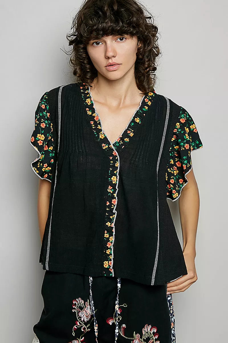 Black V-neck blouse with floral ruffle short sleeves and vertical white-stitched trim