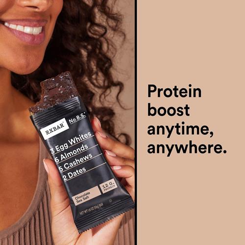 Hand holding RXBAR Chocolate Sea Salt protein bar wrapper, shown near the mouth