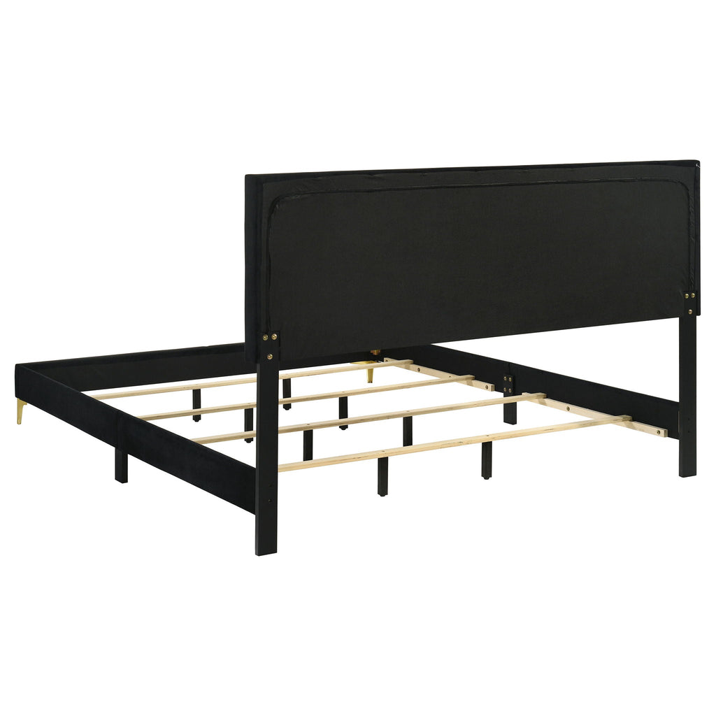 Black upholstered platform bed with slatted base, tufted headboard, and gold legs