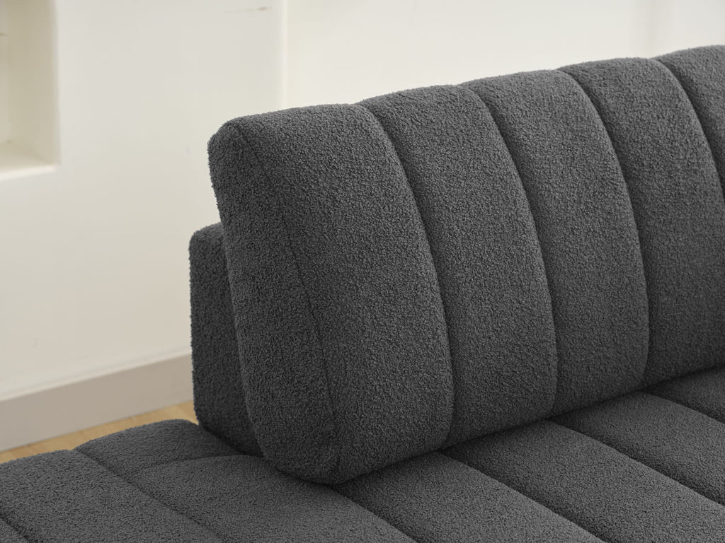 Dark gray sofa back cushion with vertical channel tufting, close-up