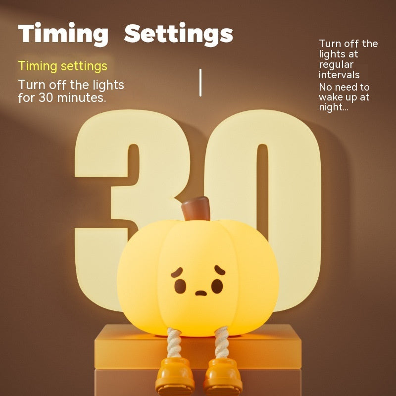 Silicone pumpkin night light with sad face, glowing on a shelf