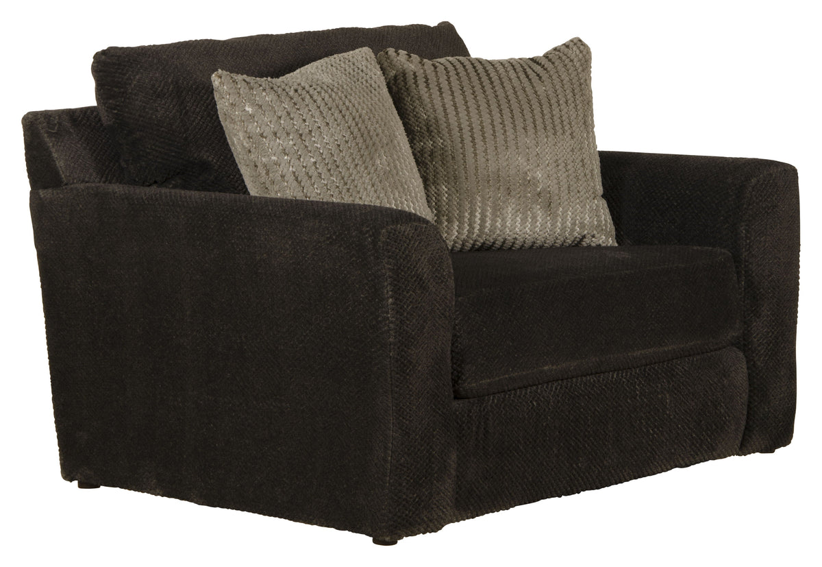 Midwood chair with dark upholstery and block arms, topped with woven throw pillows